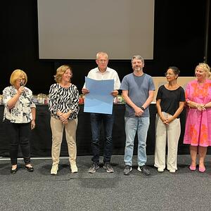 IRPD-Institutsleiter Harry Mandl übernimmt das Plakat mit dem Text von Siegi Kleinl.