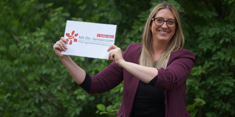 Frau hält Zettel mit PGR Logo in den Händen